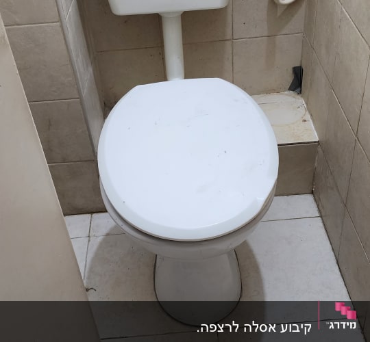 אסלה עם מיכל הדחה וצינור מים מחובר
